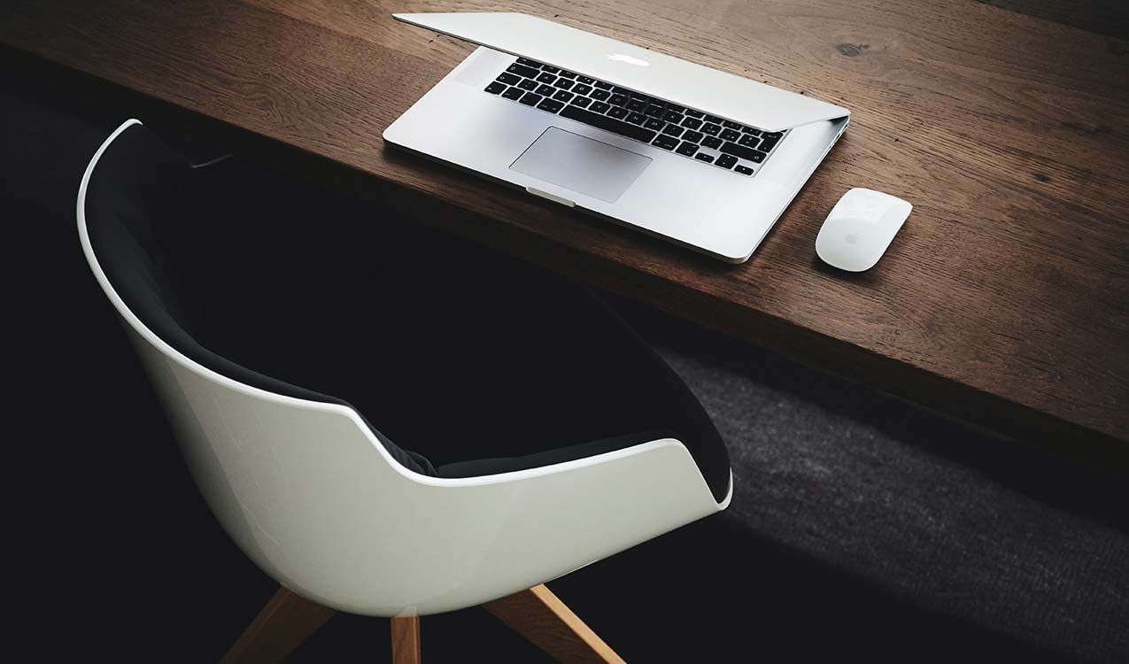 uncluttered-workspace-minimalist-modern-white-black-chair-macbook | Adept Organizer