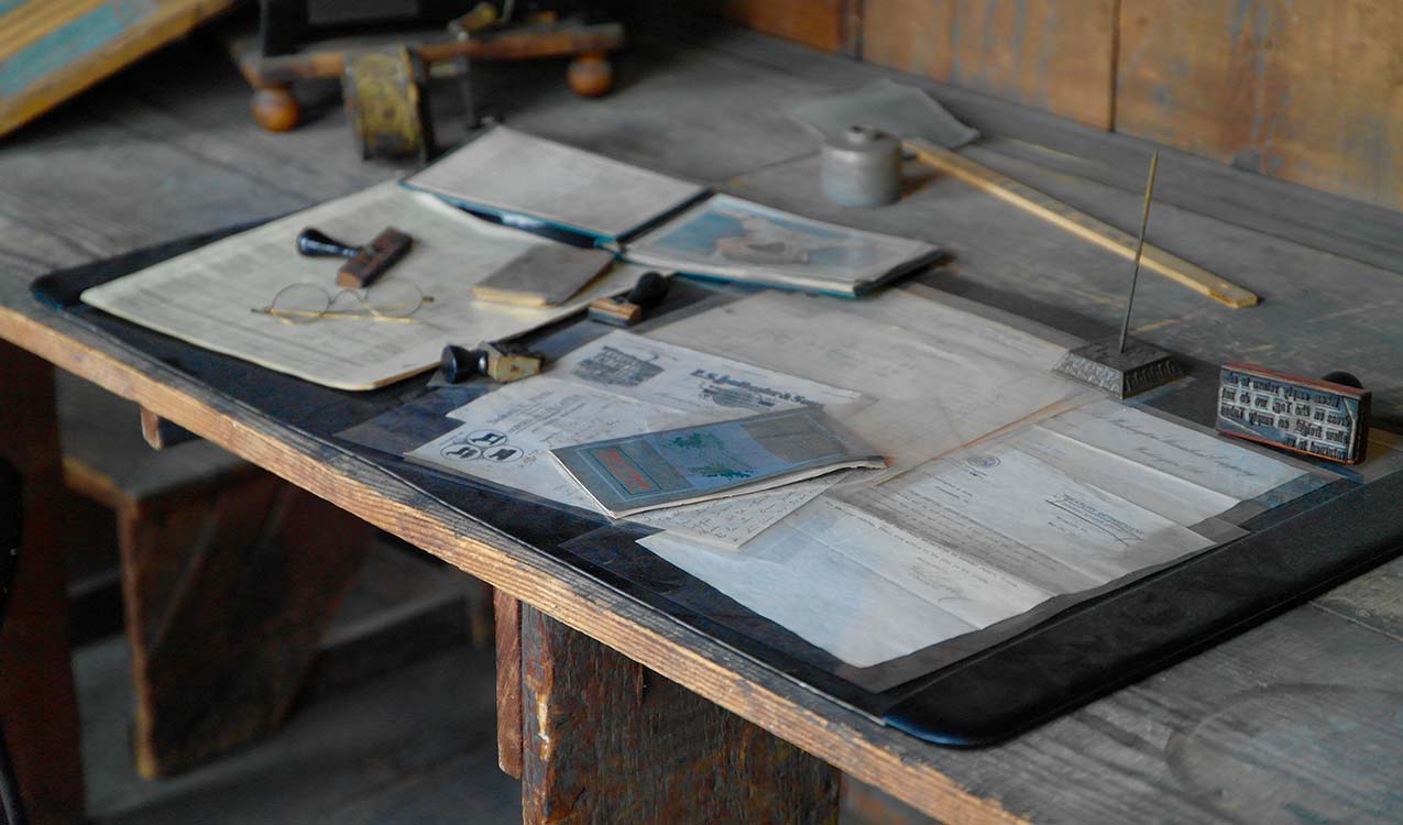 desk with assorted papers documents and clutter | Adept Organizer